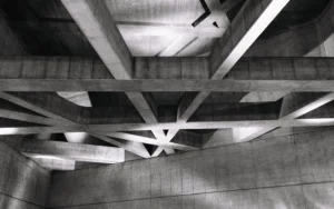 A budapesti Fővám téri metróállomás beton gerendáinak absztrakt, fekete-fehér fotója, erős fény-árnyék kontraszttal.