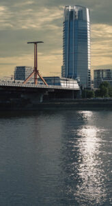 A MOL torony a Rákóczi híd mögött, ahogy a napfény aranyként csillan a Duna vizén Budapesten.